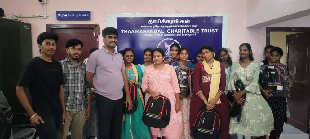 Students and staff of Thaaikarangal Charitable Trust pose together at the Digital Skilling Centre, holding backpacks provided to support education and employment opportunities for visually impaired students. Students and staff of Thaaikarangal Charitable Trust pose together at the Digital Skilling Centre, holding backpacks provided to support education and employment opportunities for visually impaired students.